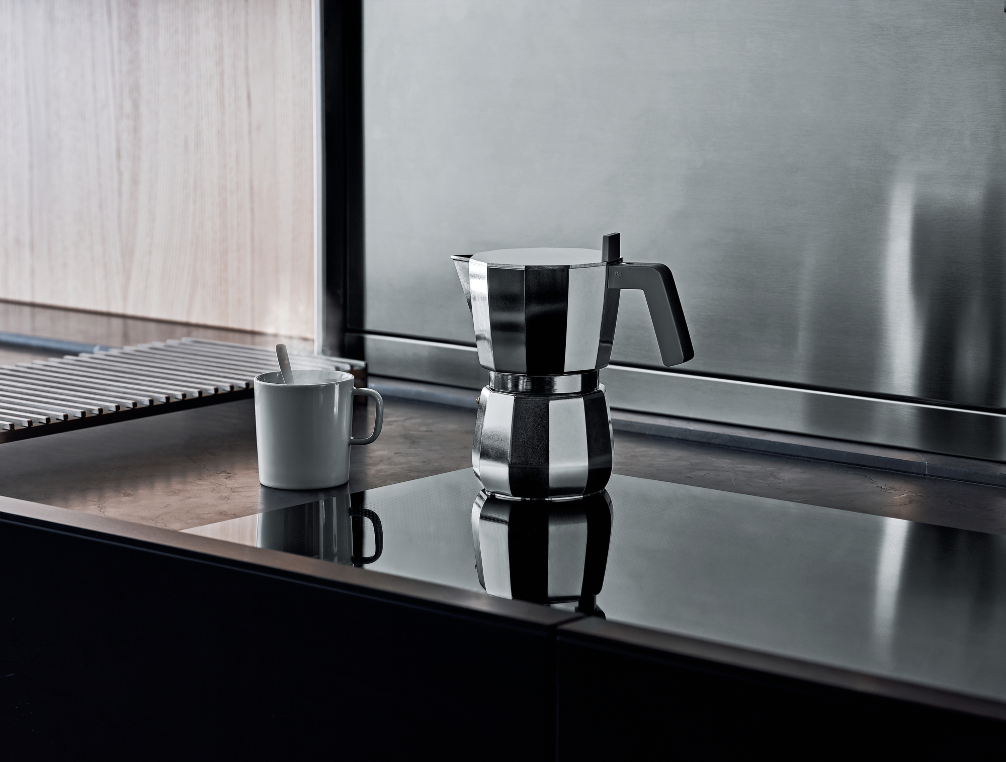 Alessi Moka Espressokocher DC06 auf einer modernen Küchenoberfläche mit Tasse. Italienischer Kaffeekocher.