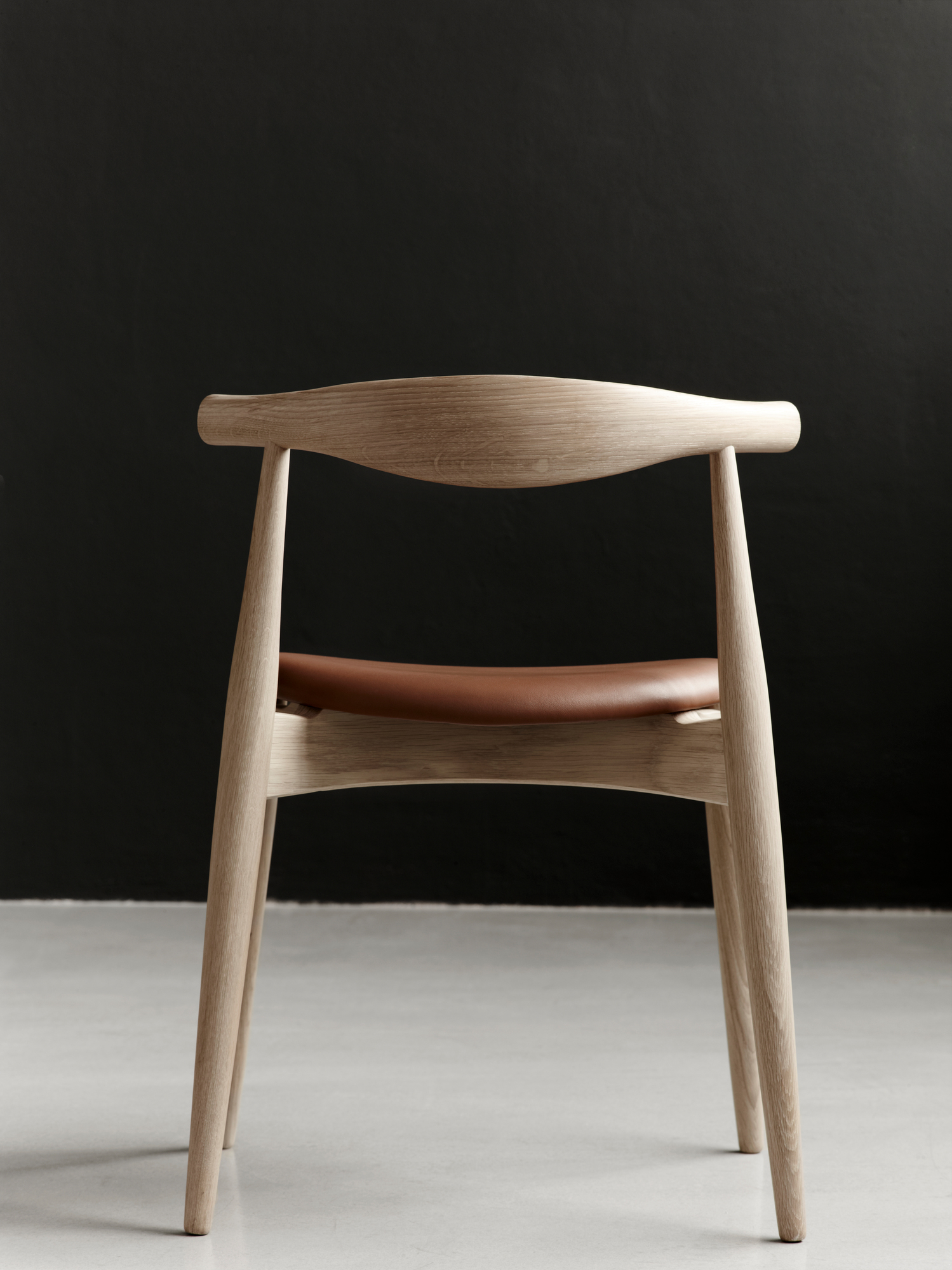 CH20 Elbow Stuhl mit Eichengestell und braunem Lederbezug, Ansicht von hinten. Designklassiker.