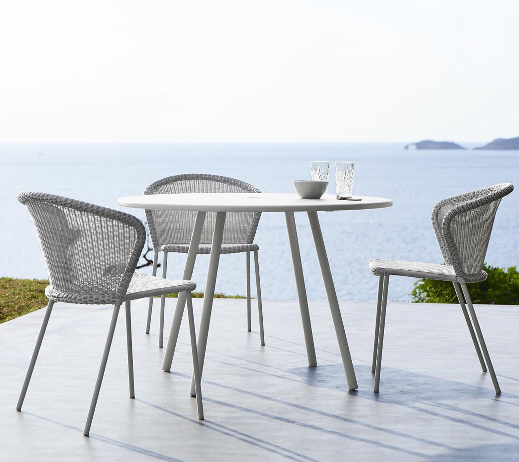 Lean Stuhl von Cane-Line, weiß mit grauem Kissen, Outdoor Möbel und Gartendesign.