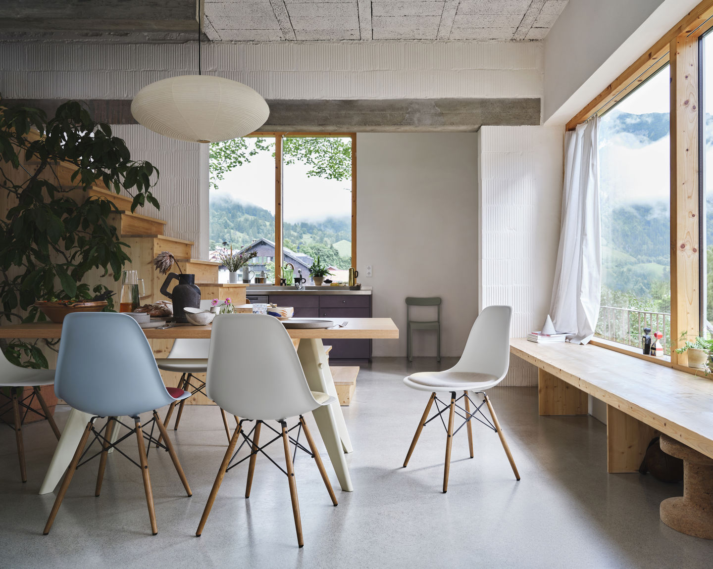 Esszimmer mit Holztisch und mehreren Vitra Eames Plastic Side Chairs DSW in verschiedenen Farben.