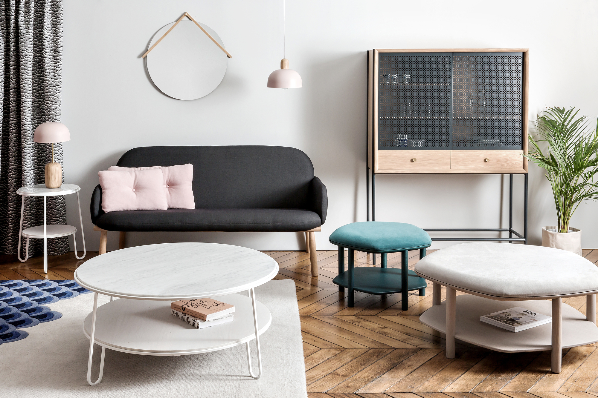 Wohnzimmer-Szene mit Gabin Cabinet Anrichte, Sofa, Couchtischen, Hocker, Spiegel und Zimmerpflanze auf einem Parkettboden.