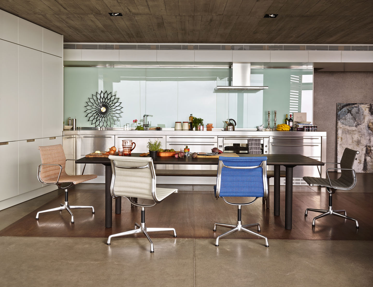 Esszimmer mit vier Aluminium Chair EA 104 Stühlen von Vitra in verschiedenen Farben.