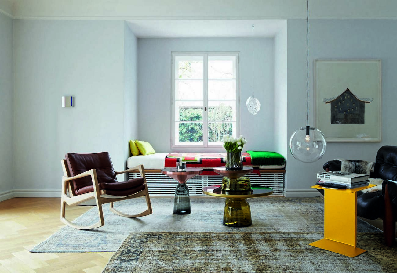 Euvira Schaukelstuhl von ClassiCon, gepolstert mit braunem Leder und hellem Holzgestell in modernem Wohnzimmer.