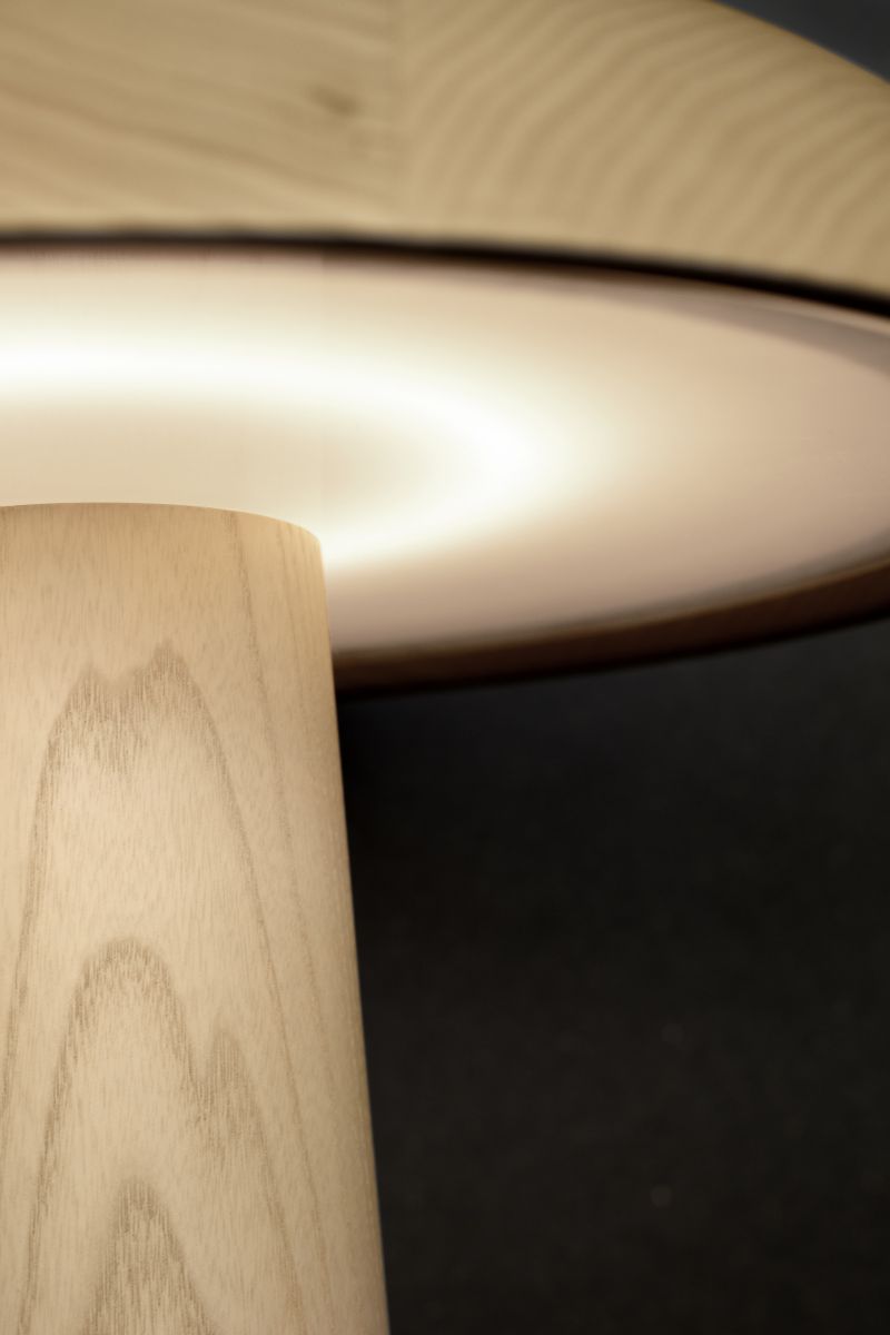 Detailaufnahme der ClassiCon Forma Tischleuchte mit Holzfuß und sanft leuchtendem Lampenschirm.