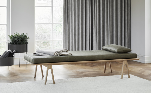 Level Daybed Liege von Woud aus Eichenholz mit olivgrüner Lederauflage und Kissen im Wohnzimmer.