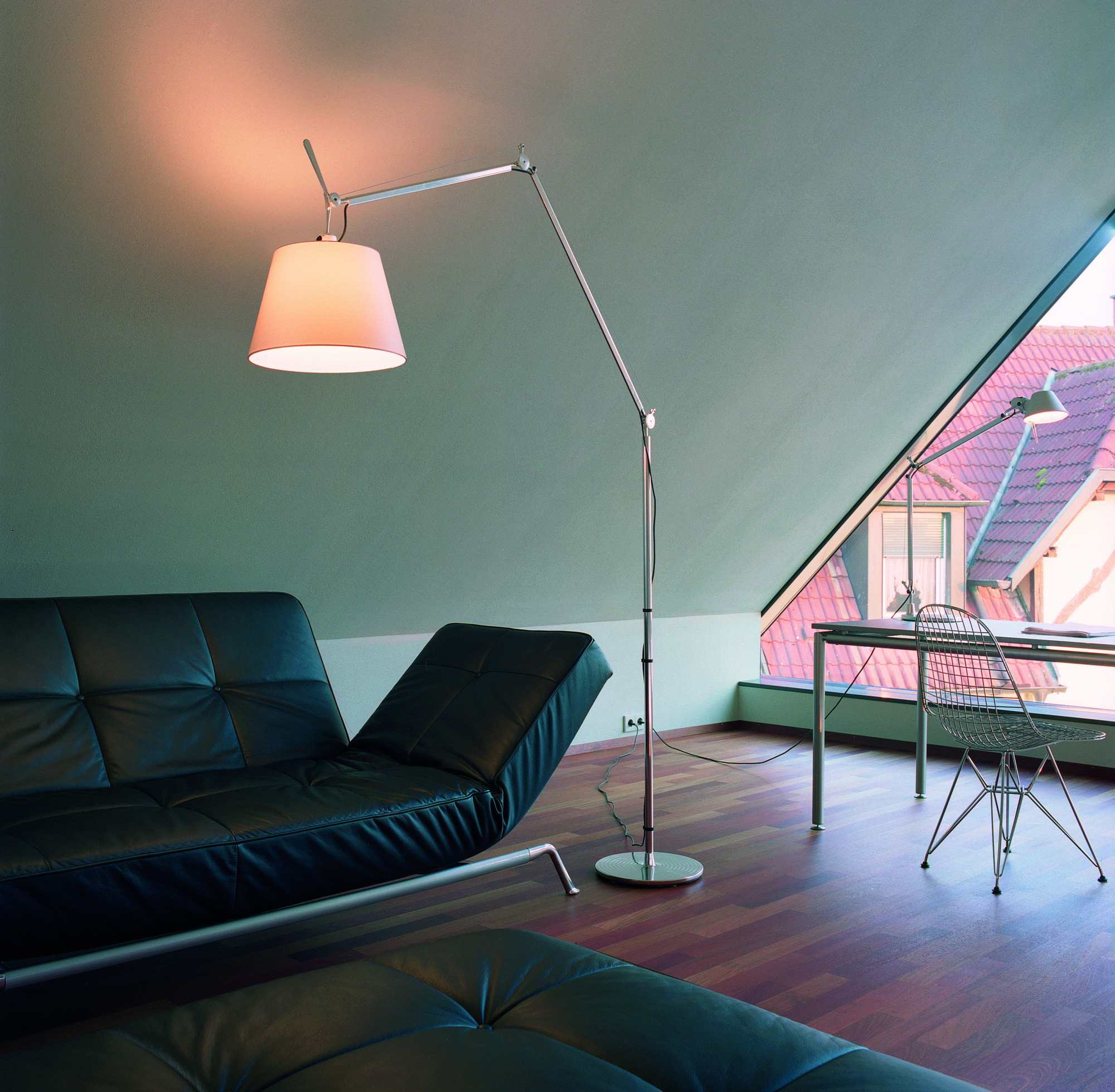 Moderne Tolomeo Mega Stehleuchte mit Dimmer von Artemide neben schwarzer Ledercouch in stilvollem Wohnzimmer.