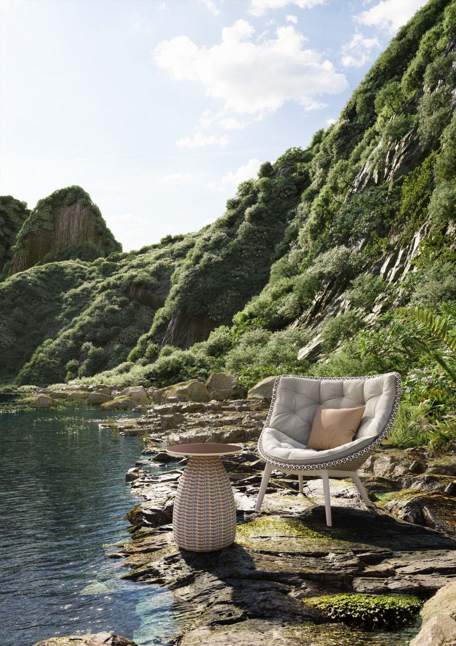 Mbrace Alu Lounge Sessel von Dedon mit Kissen und Beistelltisch am Seeufer.