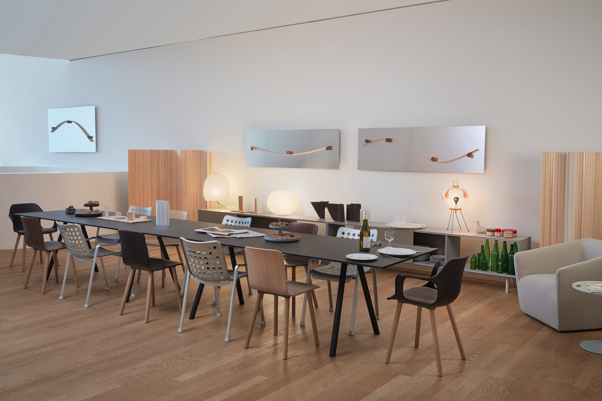 Esszimmer mit langem Tisch und verschiedenen Vitra Hal Ply Wood Stühlen in modernem Design.