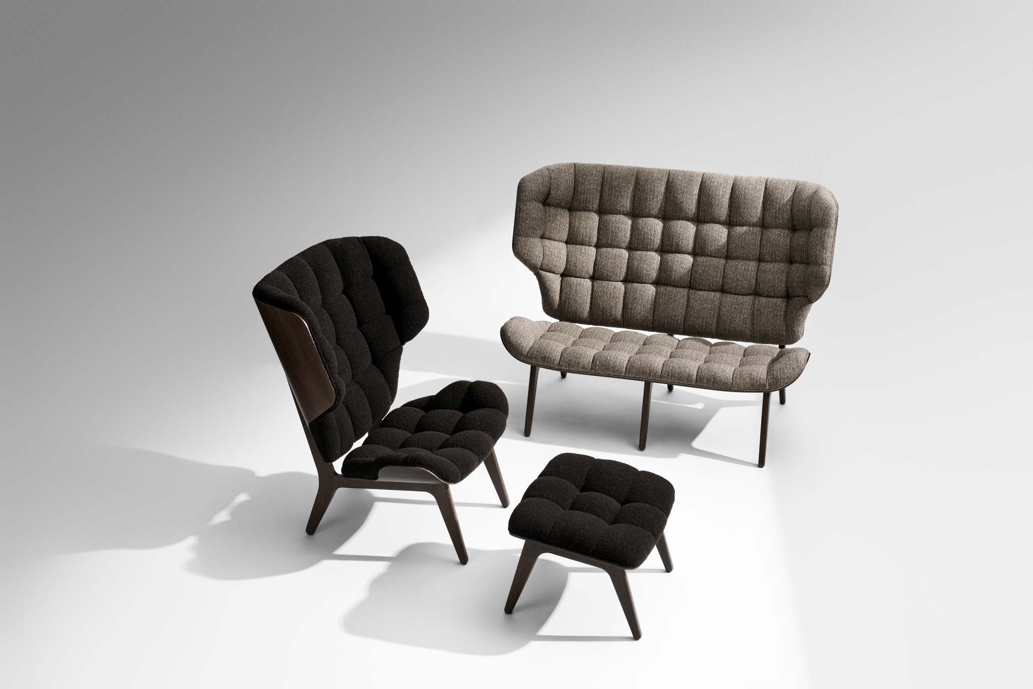 NORR11 Mammoth Ottoman in Schwarz, Sessel und Sofa mit gesteppter Polsterung im Studio.