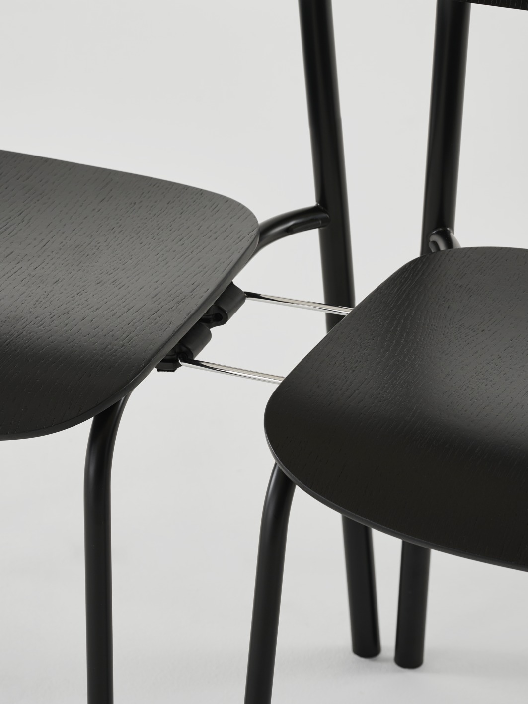 Detailaufnahme von zwei schwarzen Thonet S 243 Stahlrohrstühlen mit olivgrünem Finish, modernes Möbeldesign für Esszimmer und Wohnbereich.