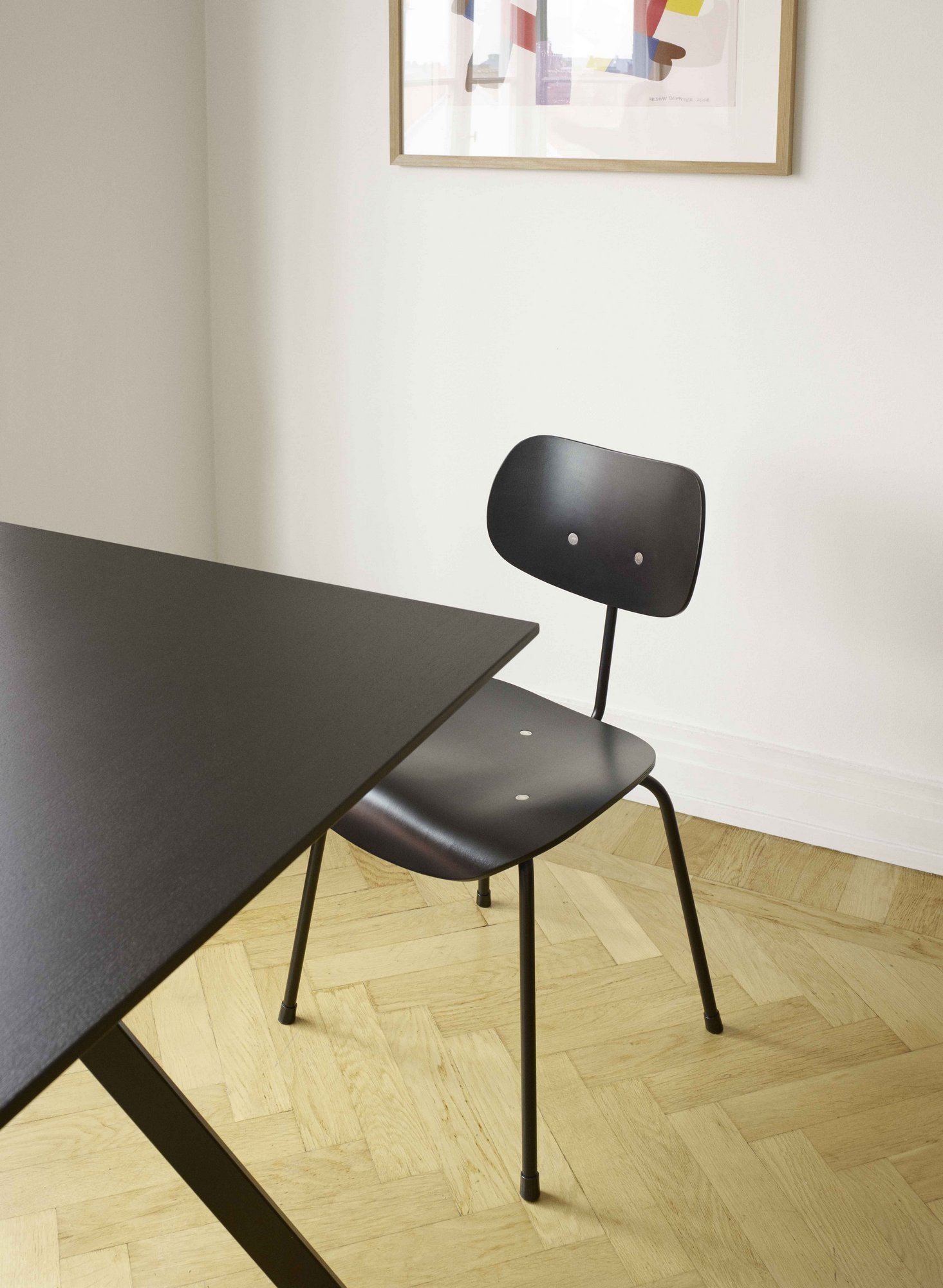 Schwarzer SE 68 Stuhl von Wilde+Spieth neben einem Tisch auf hellem Parkettboden, minimalistisches Design.