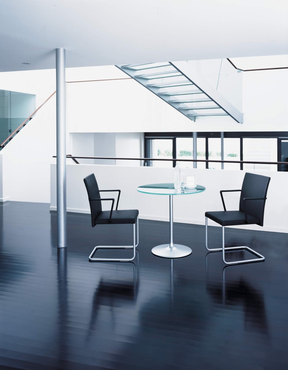 Zwei JASON LITE Stühle von Walter Knoll in schwarzem Leder und Chromgestell an Glastisch.