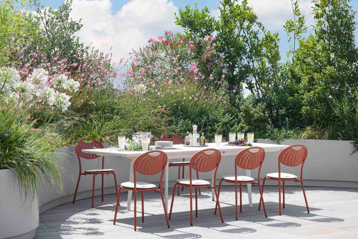 Coupole Stuhl von Emu für den Außenbereich: Gartenstuhl aus Metall in Terrakotta mit Sitzkissen.