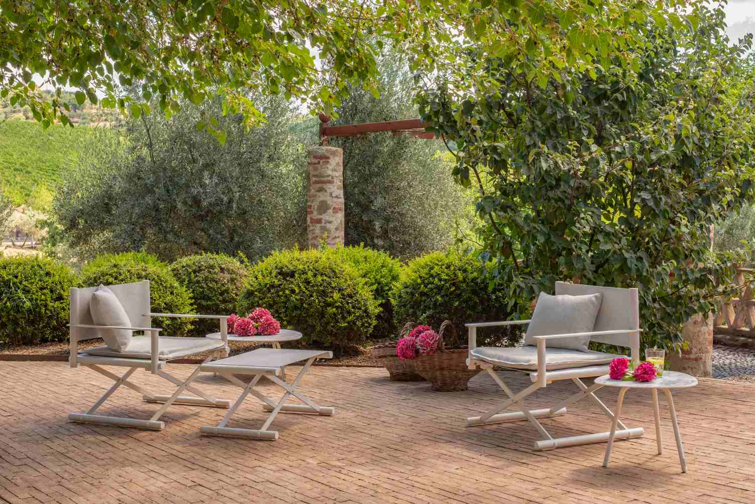 Terra Lounge Chair Outdoor Sessel von Emu auf einer Terrasse mit Beistelltisch und Gartenmöbeln.
