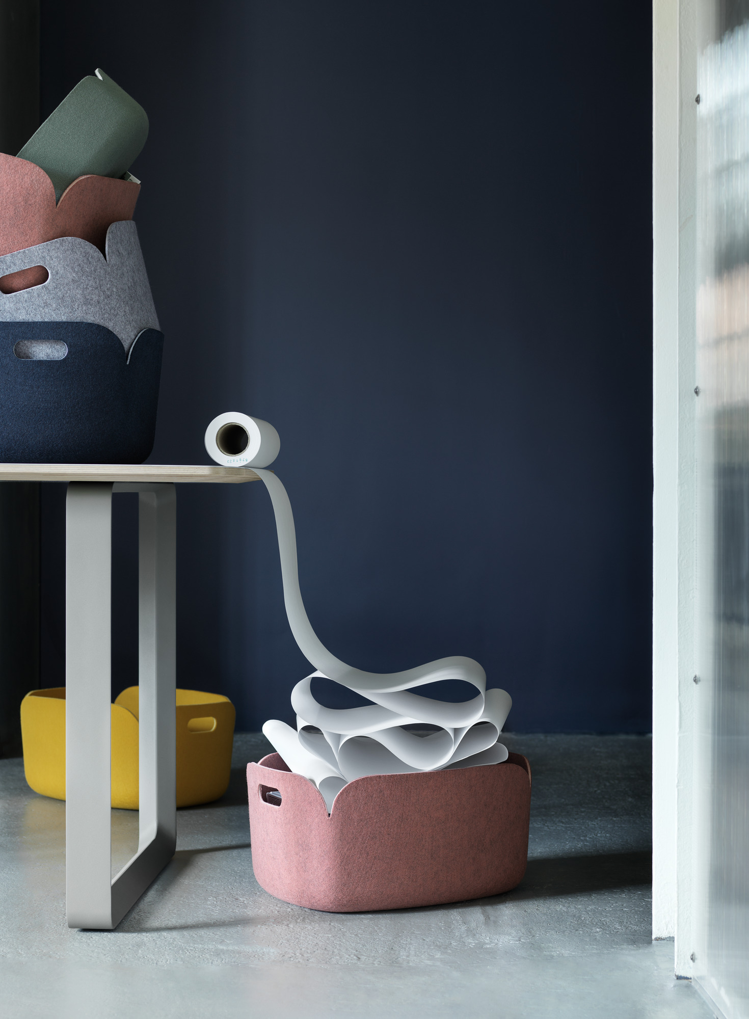 Muuto 70/70 Table Tisch 225x90 cm mit farbigen Filzkörben und Papierrolle im modernen Büro.