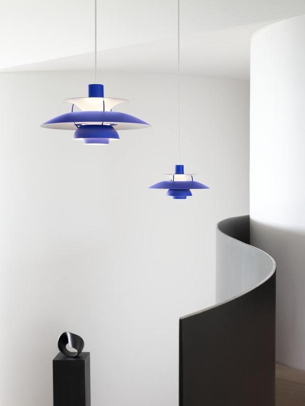 Zwei blaue PH 5 Mini Pendelleuchten von Louis Poulsen hängen in einem modernen Treppenhaus.
