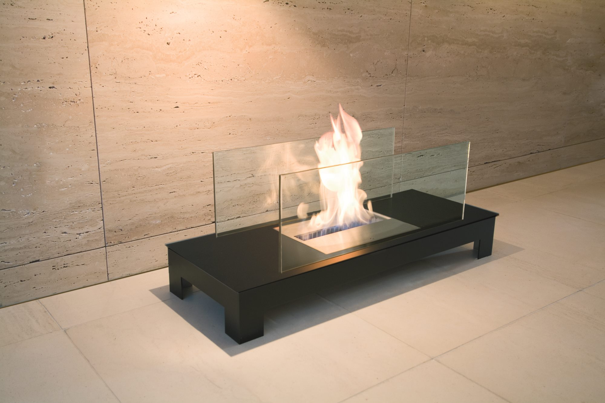 Floor Flame Ethanol Kamin: Schwarzer Tischkamin mit Glas und brennender Flamme.