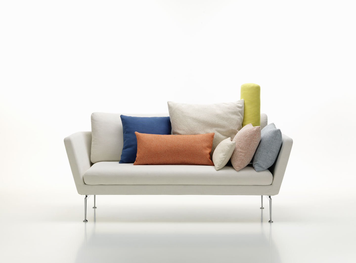 Weißes Sofa mit verschiedenen Vitra Cushions Kissen in Blau, Orange, Beige und Gelb. Sofakissen für Wohnzimmer.