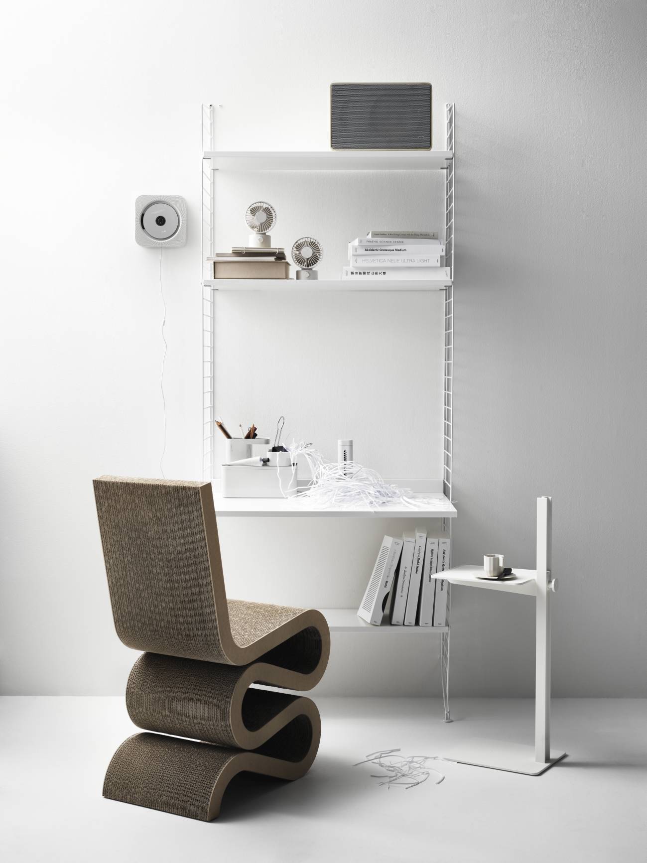 Arbeitsplatz mit String Furniture Regalsystem in Weiß und Design Stuhl. Büro und Wohnen.