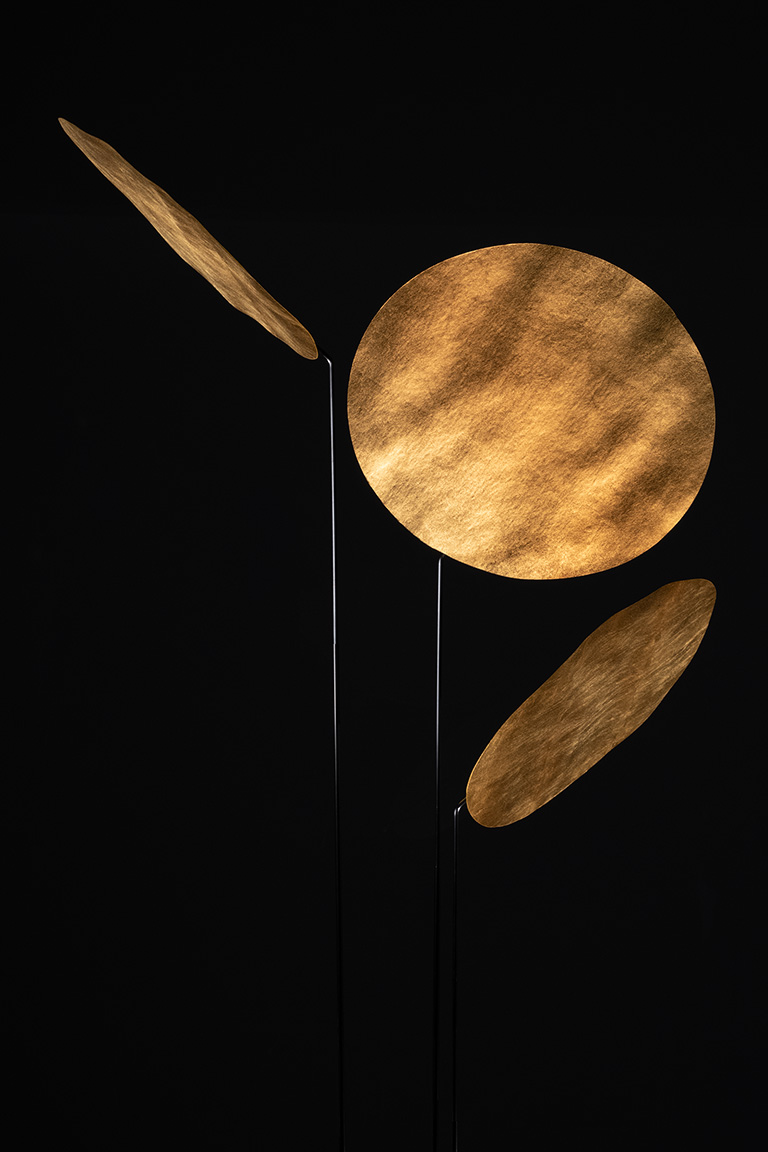 Nuunu Stehleuchte: Moderne Designerlampe mit goldenen Reflektoren und filigranem Gestell für stimmungsvolle Beleuchtung.