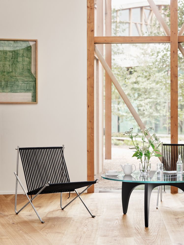 PK4 Lounge Chair von Fritz Hansen mit schwarzer Kordelbespannung und Stahlgestell in modernem Interieur.