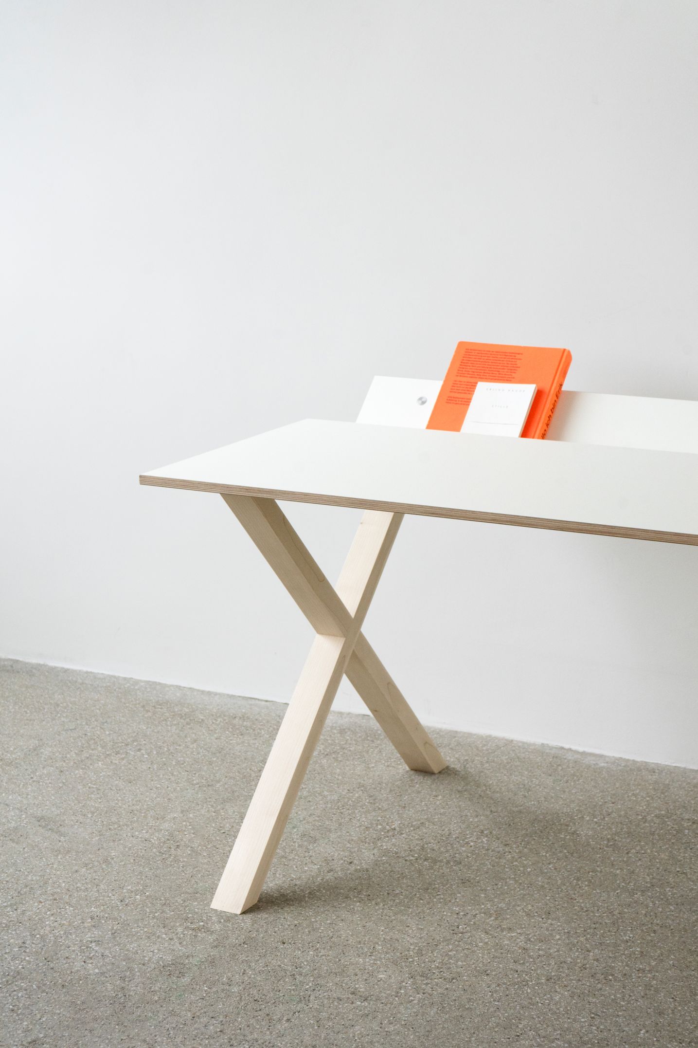 Kant Schreibtisch von Nils Holger Moormann, weiß mit hellem Holzgestell in X-Form, minimalistisches Design.