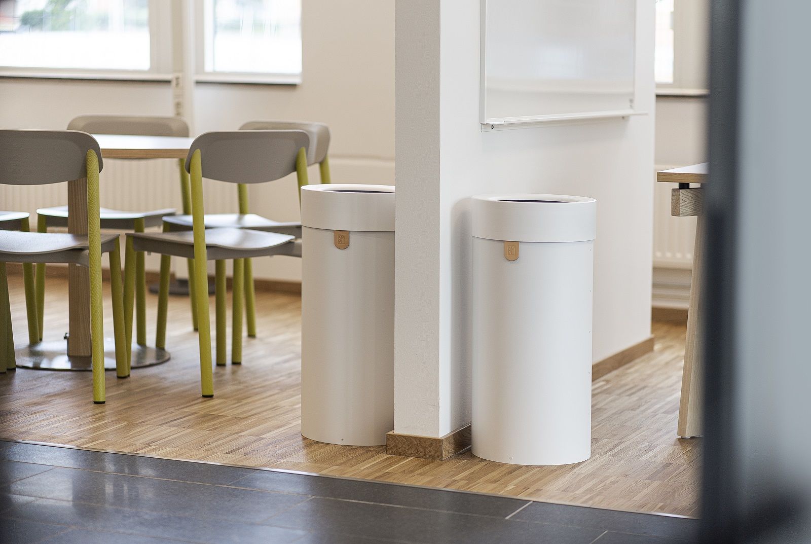 Zwei weiße Bin There Mülleimer für Mülltrennung im Büro, minimalistisches Design.