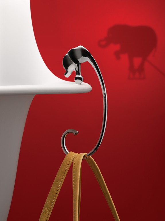 Alessi Jumbo Taschenhaken mit Elefantenkopf hält eine Handtasche an einer Tischkante.