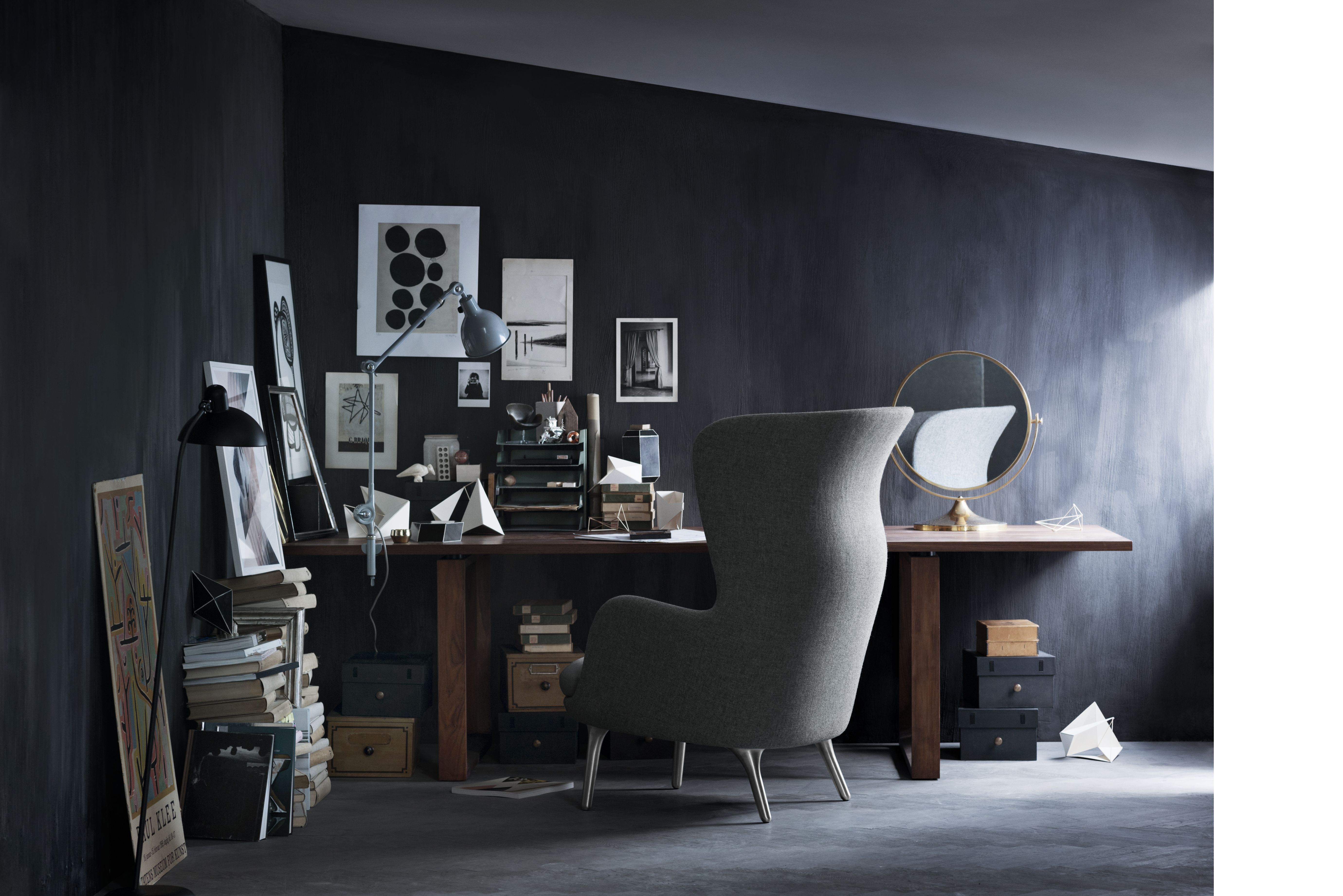 Grauer Ro Sessel von Fritz Hansen aus Aluminium vor einem Schreibtisch in dunklem Raum.