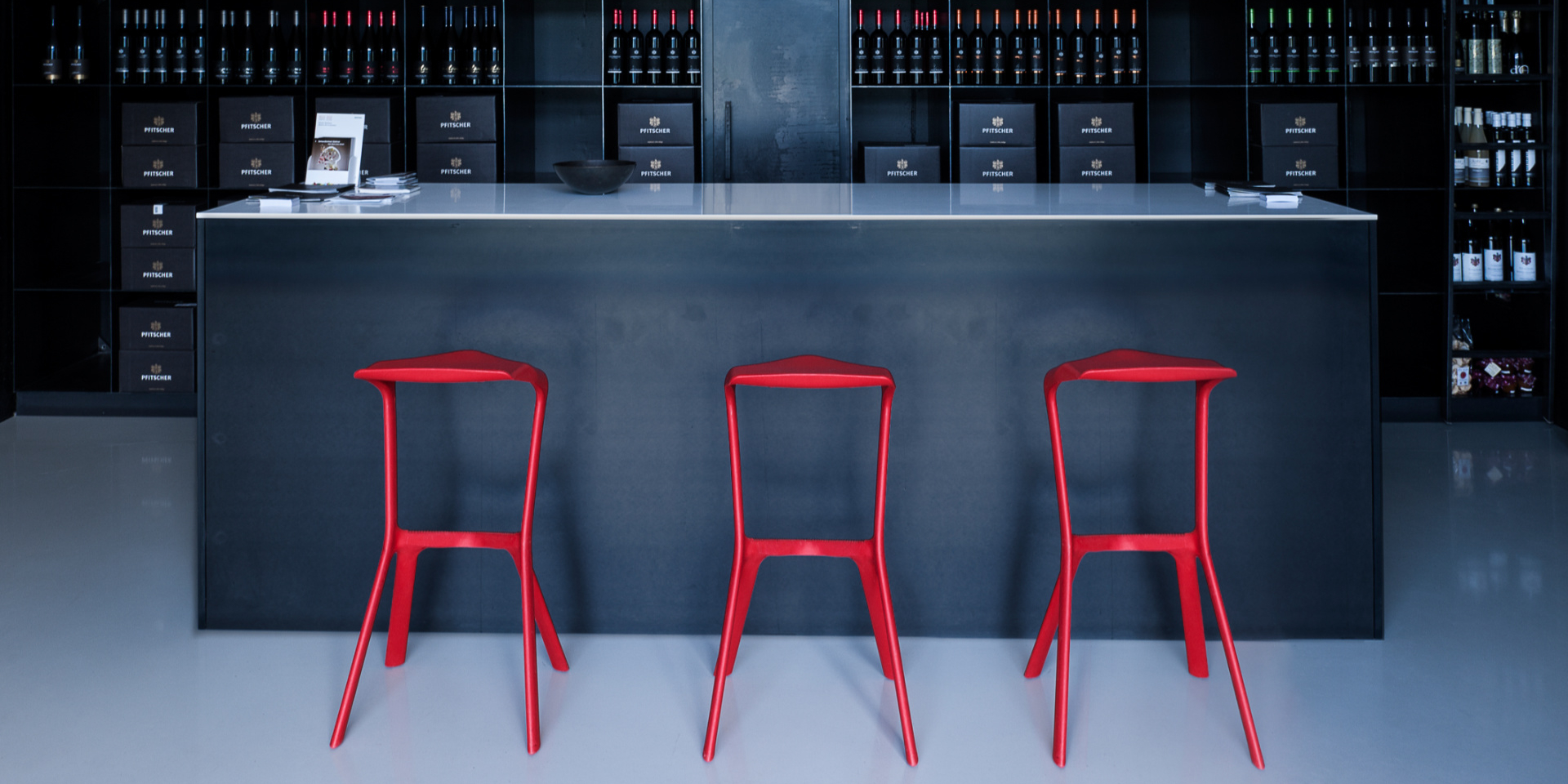 Drei rote Miura Barhocker vor einer Bar. Design Hocker für Küche und Gastronomie.