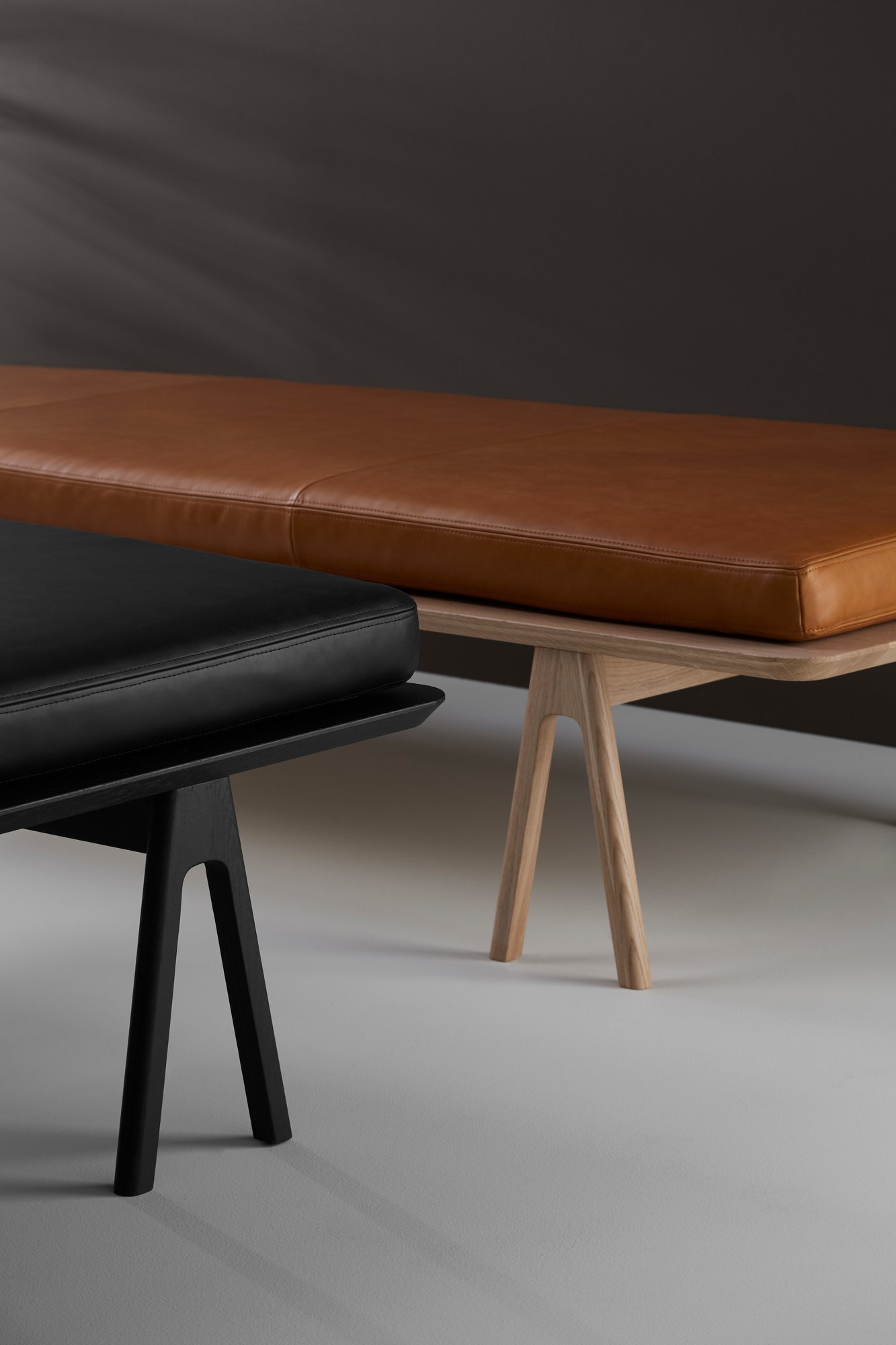 Detailaufnahme: Schwarze und braune Level Daybeds von Woud mit Holzgestell.