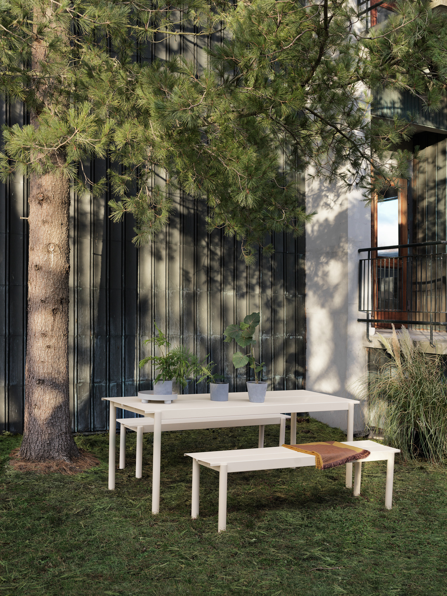 Muuto Linear Steel Outdoor Tisch mit Bänken im Garten, modernes Design für den Außenbereich.