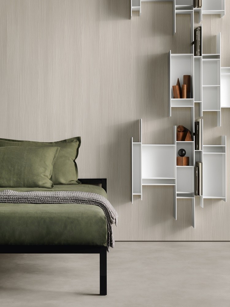 Modernes Schlafzimmer mit Aluminium Bettgestell, grüner Bettwäsche und weißem Wandregal von MDF Italia.