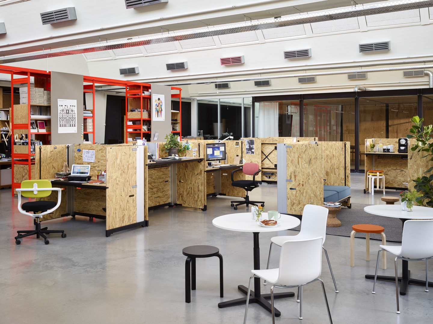 Büro mit Arbeitsplätzen, Besprechungstischen und einem schwarzen Allstar Bürodrehstuhl von Vitra mit atmungsaktivem Netzgewebe.