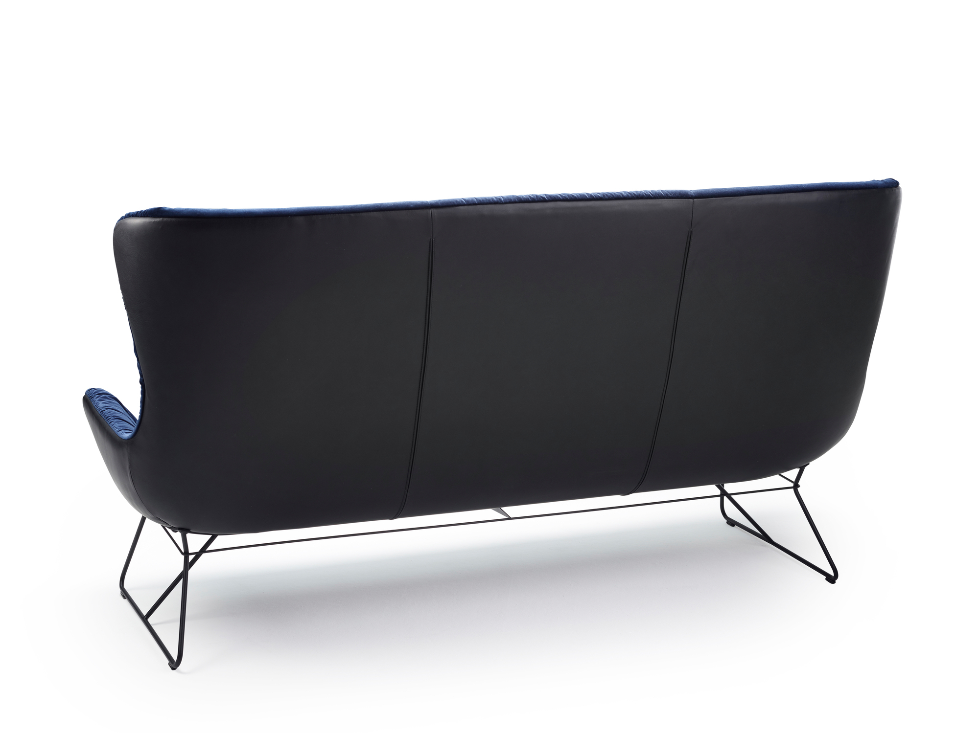 Rückansicht der Leya Couch von Freifrau Manufaktur mit schwarzem Leder und blauem Samt.
