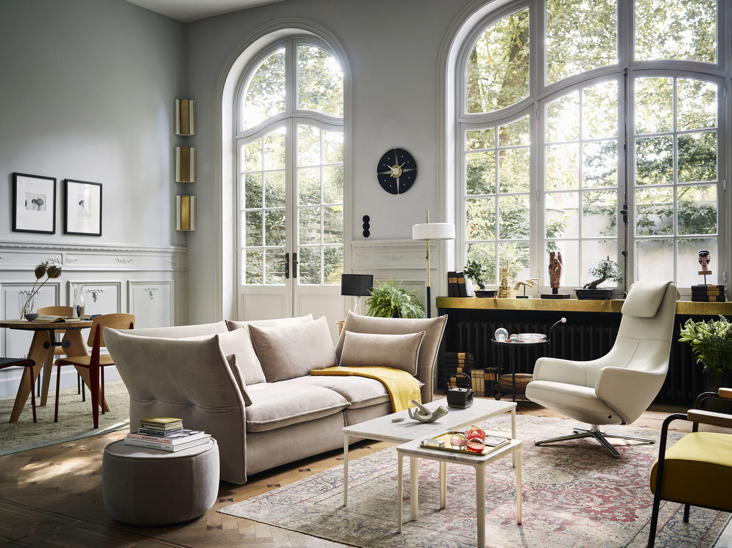 Helles Wohnzimmer mit Vitra Standard Stühlen am Esstisch und beigem Sofa mit Kissen.