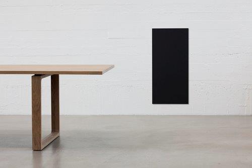 Essay Tisch von Fritz Hansen mit heller Tischplatte und Holzgestell vor weißer Wand.