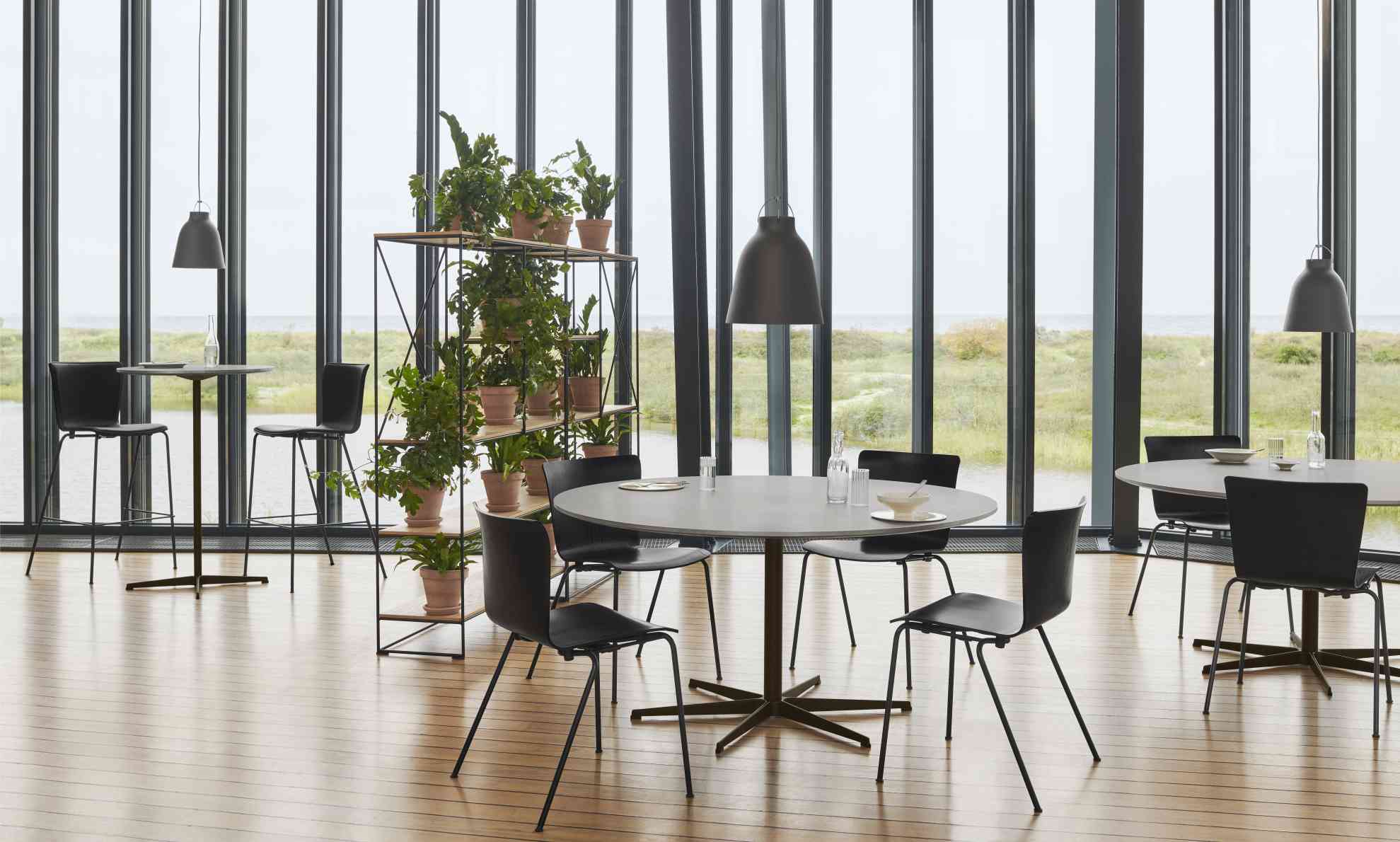 Heller Raum mit Fritz Hansen Zirkular Tisch, runder Esstisch mit Stühlen und Meerblick.