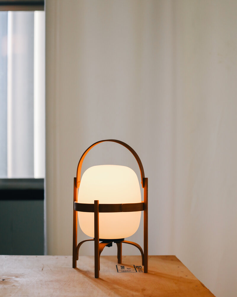 Cestita Batería Akkuleuchte von Santa & Cole: Tragbare Tischlampe mit warmem Licht und Holzgestell.
