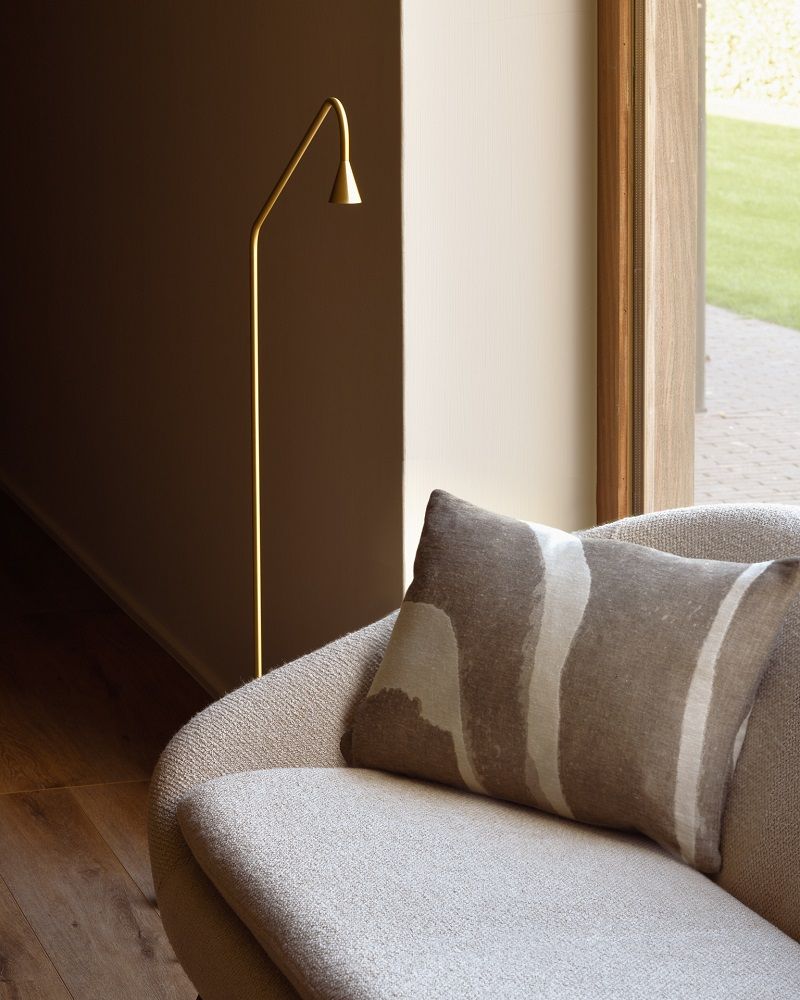 Detailaufnahme vom Ethnicraft Barrow Sofa 2-Sitzer in Off-White mit Kissen und goldener Stehlampe im Hintergrund.