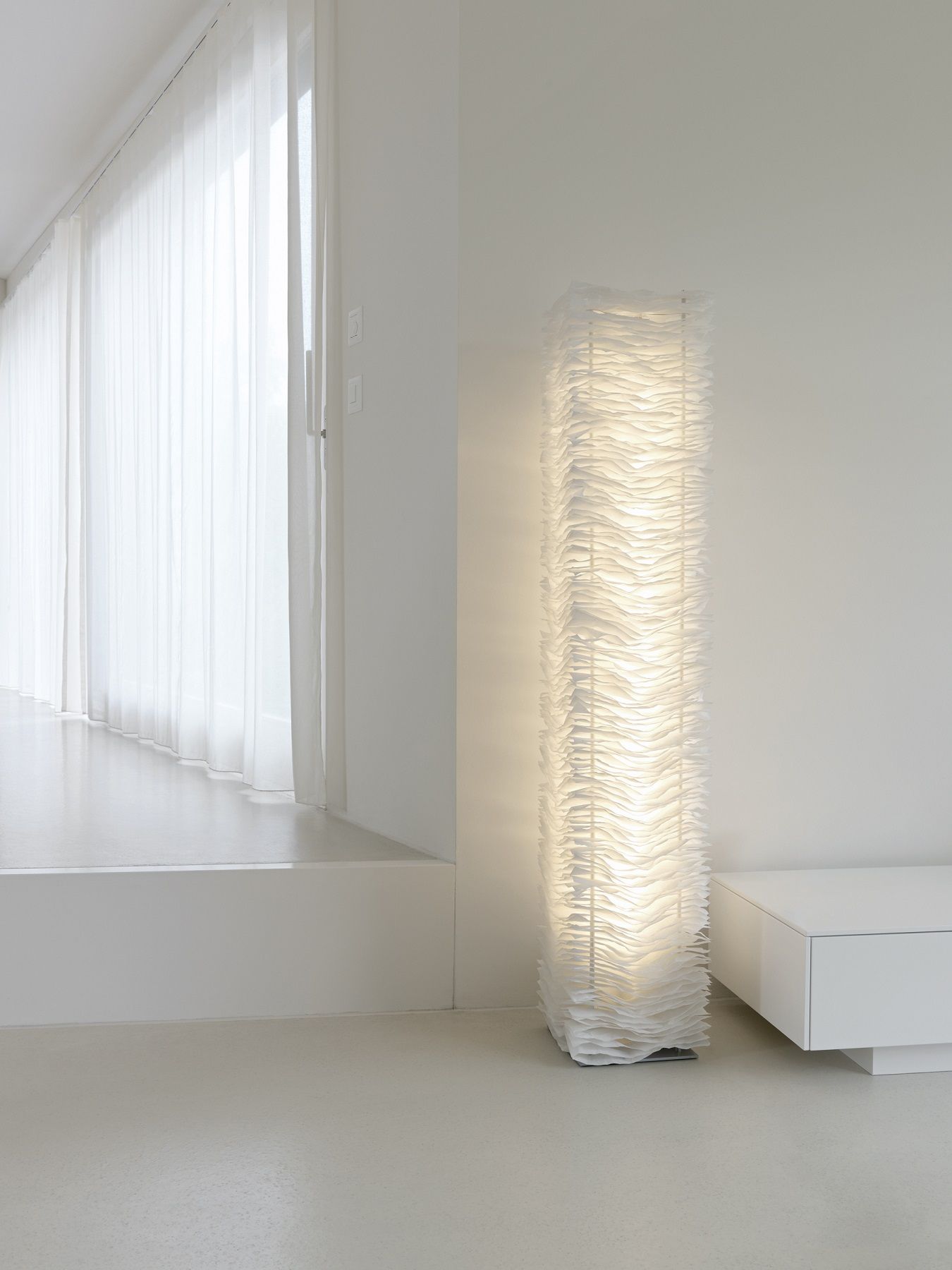 Weiße Stehlampe mit Papierdesign im minimalistischen Wohnzimmer, modernes Licht für stilvolle Inneneinrichtung.