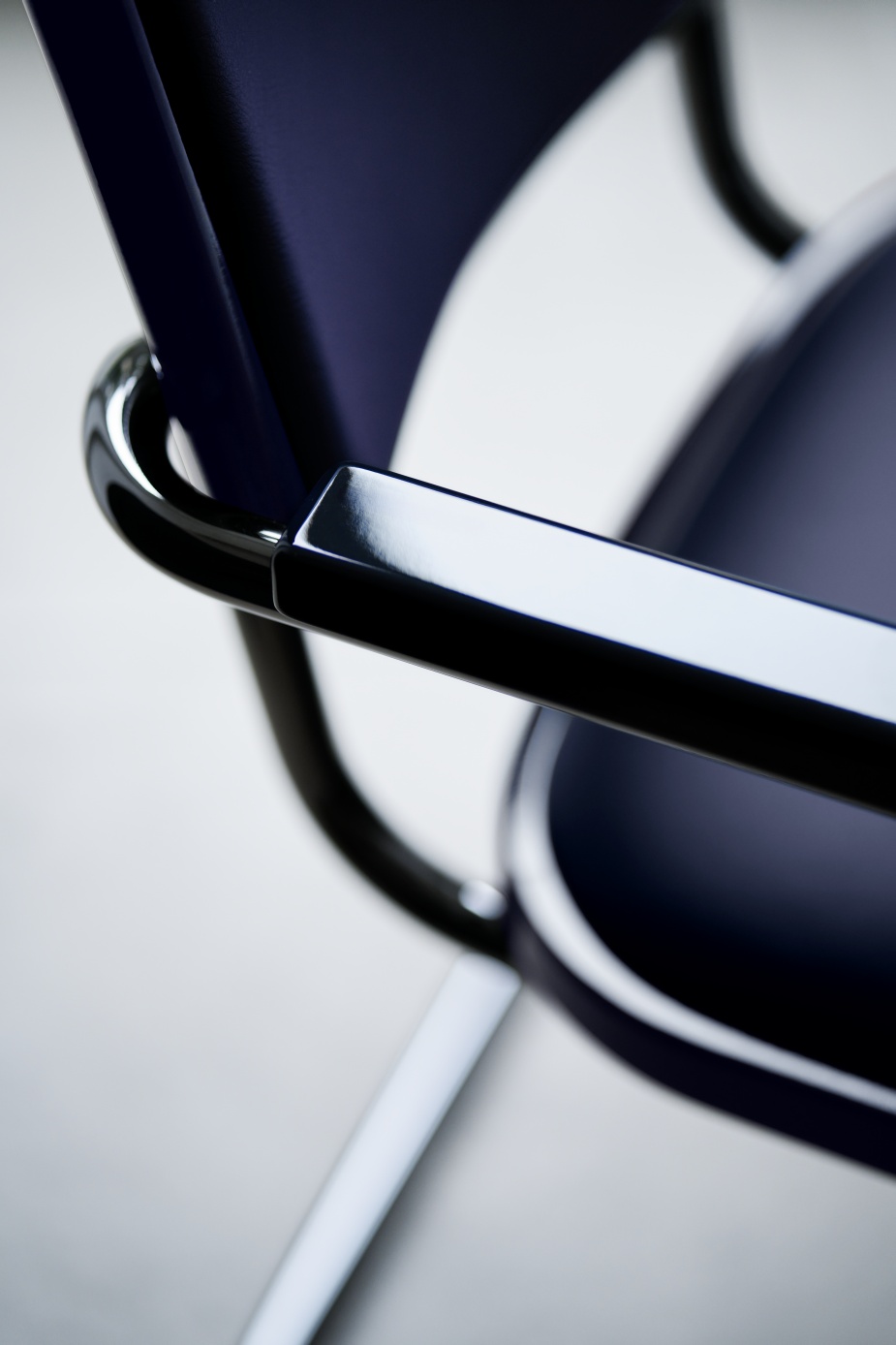 Detailaufnahme des JS. Thonet S 64 P Freischwinger Stuhls mit blauem Bezug und glänzendem, schwarzem Stahlrohrgestell.