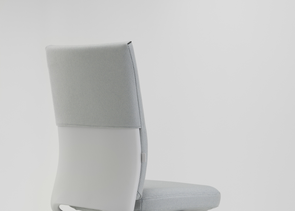 Detailaufnahme der Rückenlehne des Vitra ID Soft Bürodrehstuhls in hellgrauem Stoffbezug und glattem, hellgrauem Kunstleder.