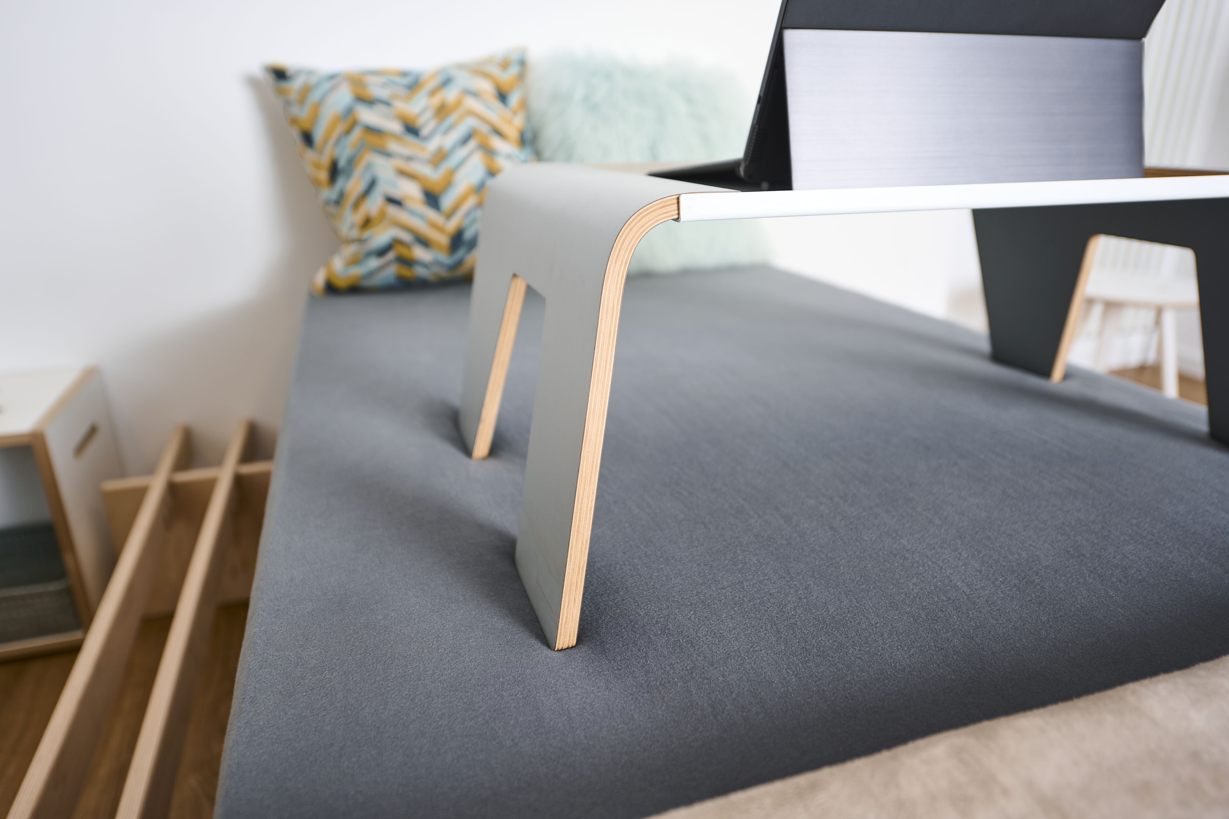 Tojo Notebook-Tablett auf einem Bett mit Laptop, ideal als Frühstückstablett oder Betttisch.