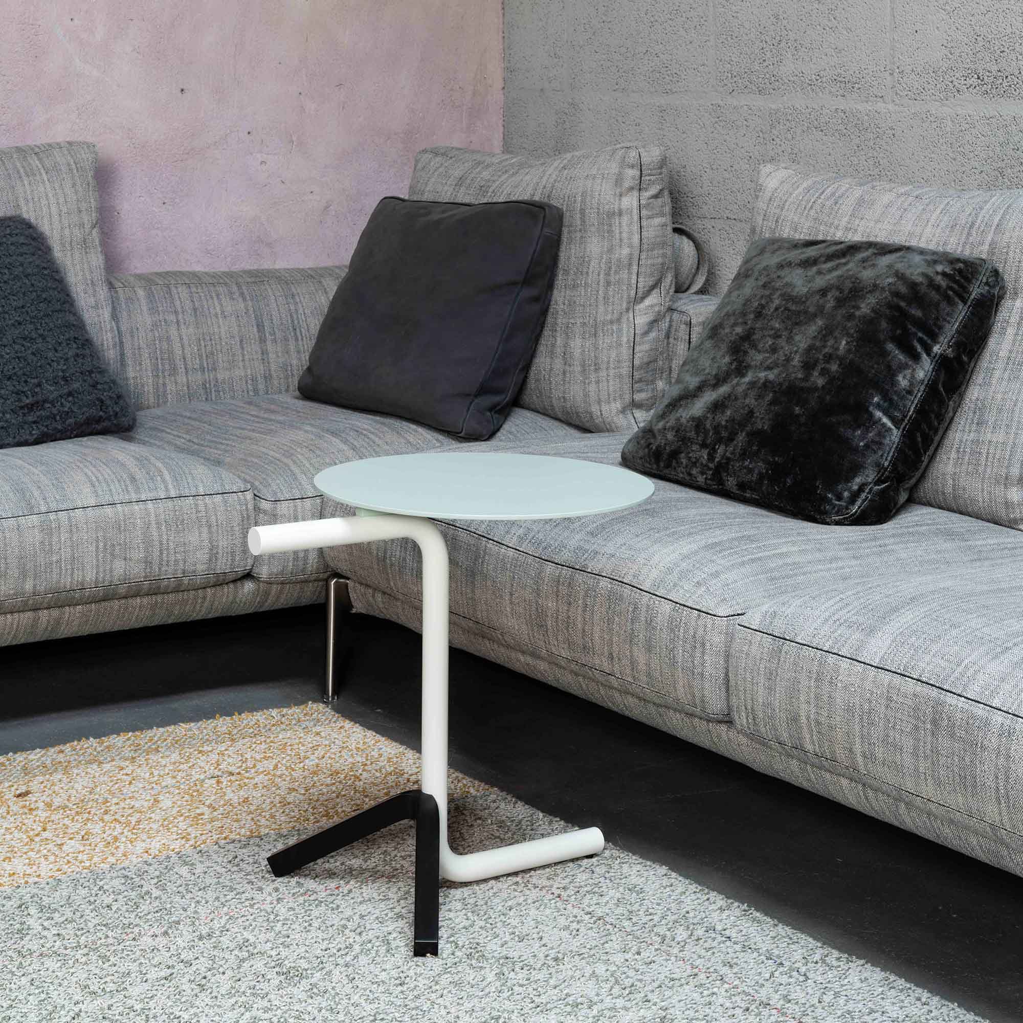 Aso Beistelltisch von Mox mit runder, mintfarbener Tischplatte und weißem Gestell neben grauem Sofa.