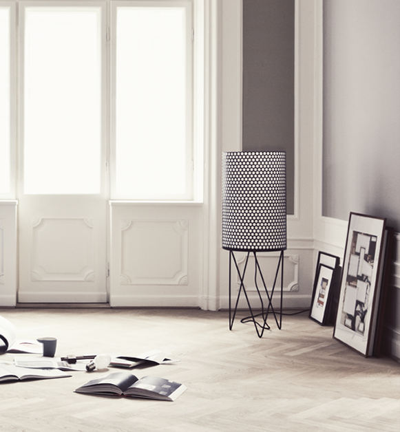 Pedrera Stehleuchte PD2 von Gubi im minimalistischen Wohnzimmer mit Parkettboden und Kunst an der Wand.