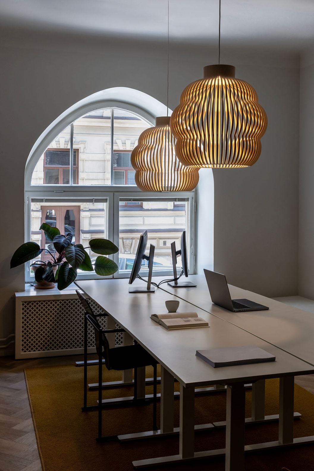 Zwei Kumulo Pendelleuchten aus Birke von Secto Design über einem modernen Bürotisch.