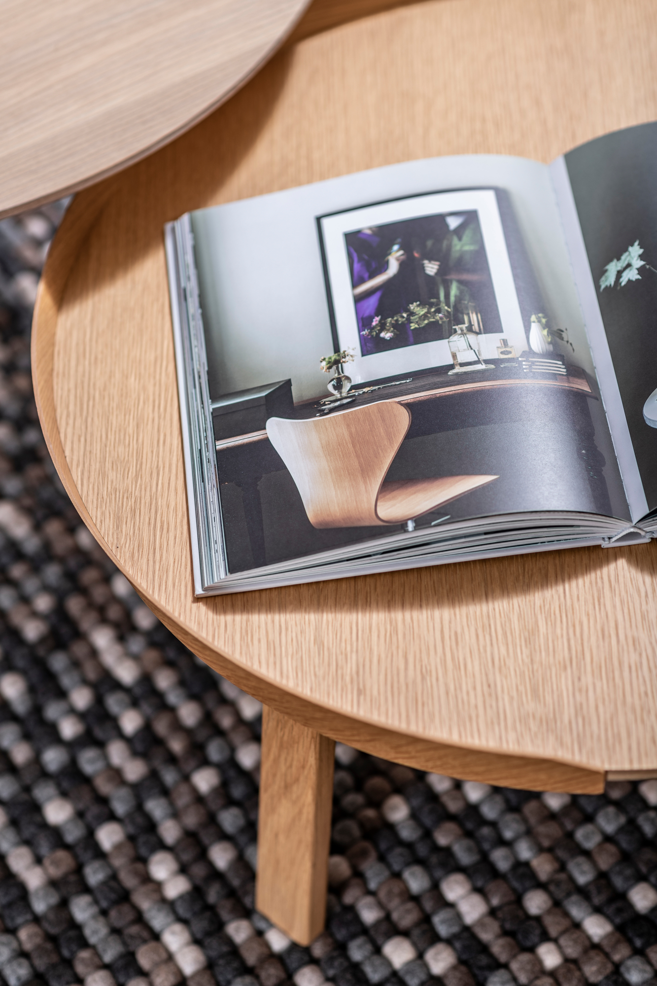 Detailaufnahme des Muuto Around Coffee Table Large aus Eiche mit Zeitschrift auf einem Teppich.