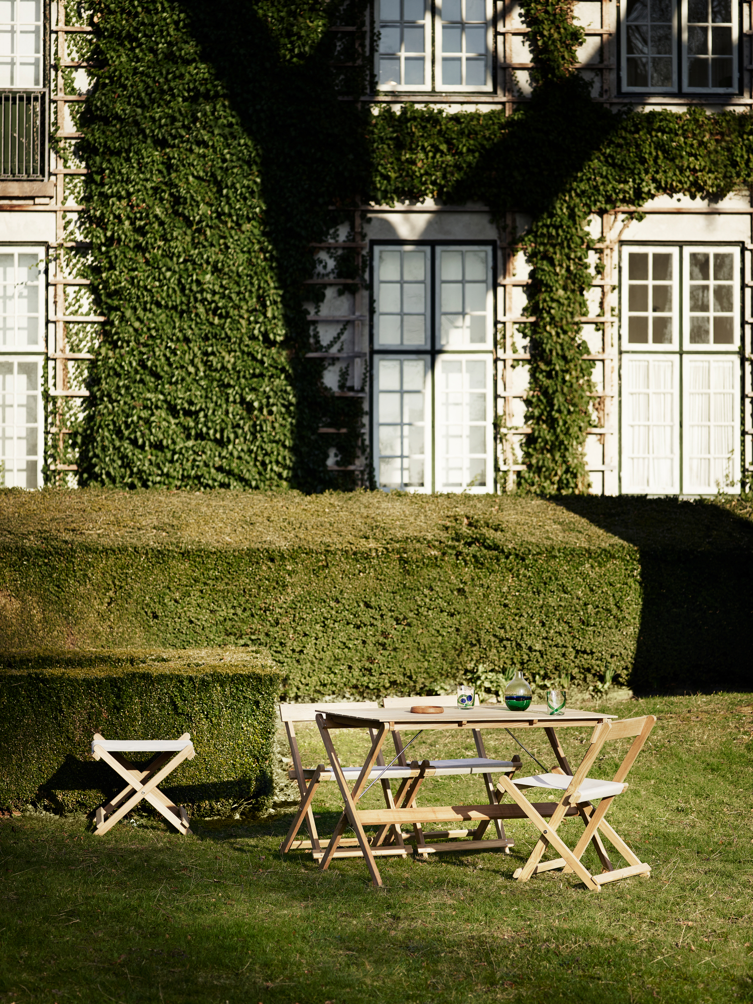 BM5768 Borge Mogensen Outdoor Hocker und Gartentisch-Set von Carl Hansen & Søn im Garten.