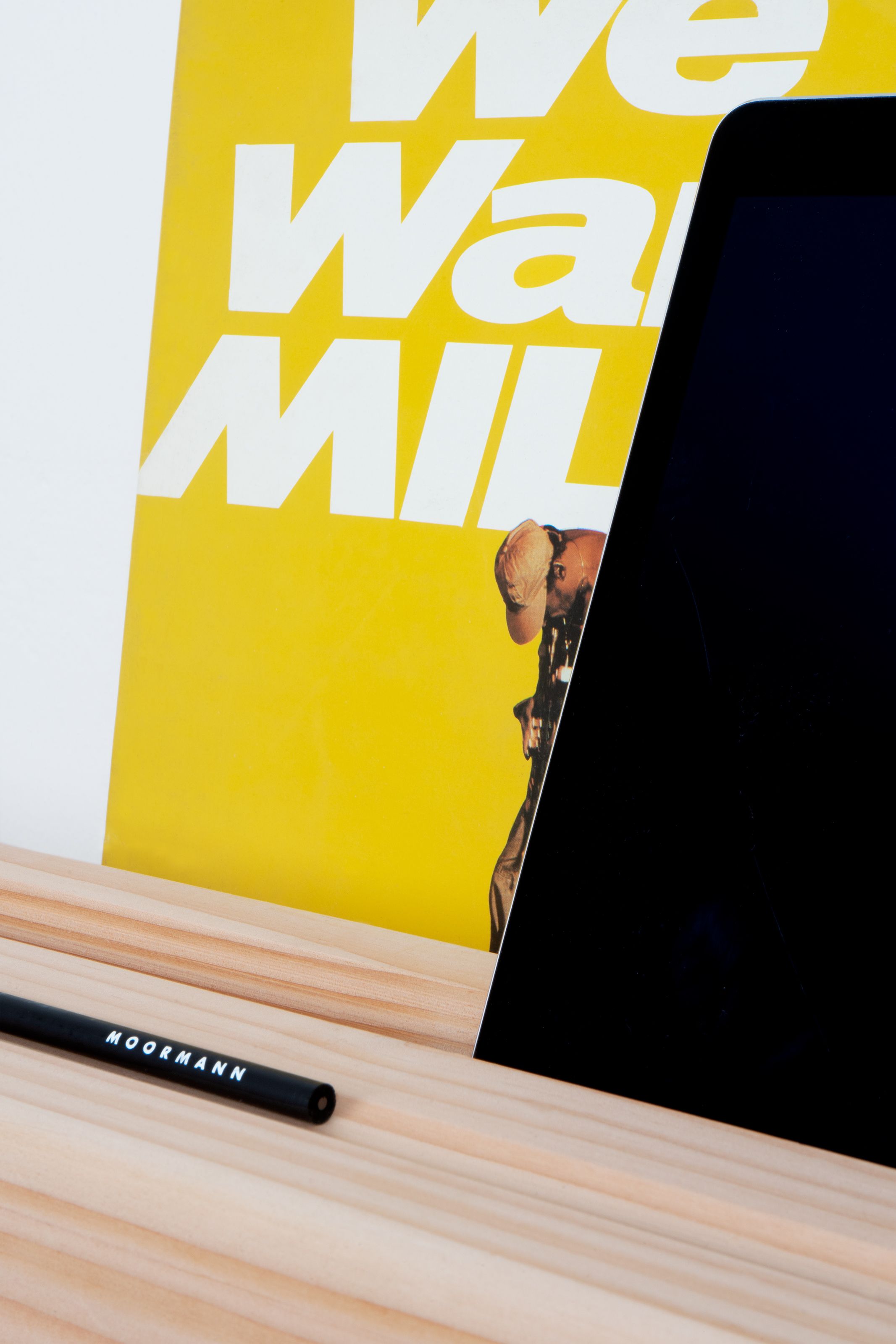 Detailaufnahme des Moormann Kurt Sekretärs mit Laptop, Stift und gelbem Poster im Hintergrund.